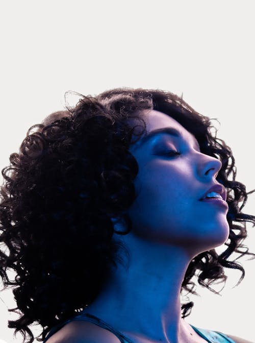 A Curly Haired Woman with Her Eyes Closed