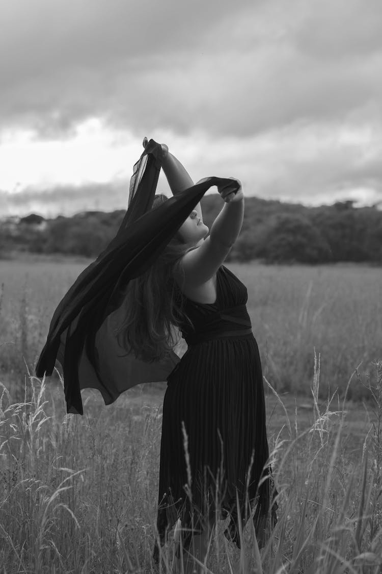 Black And White Photo Of Woman With Veil Dancing In Field