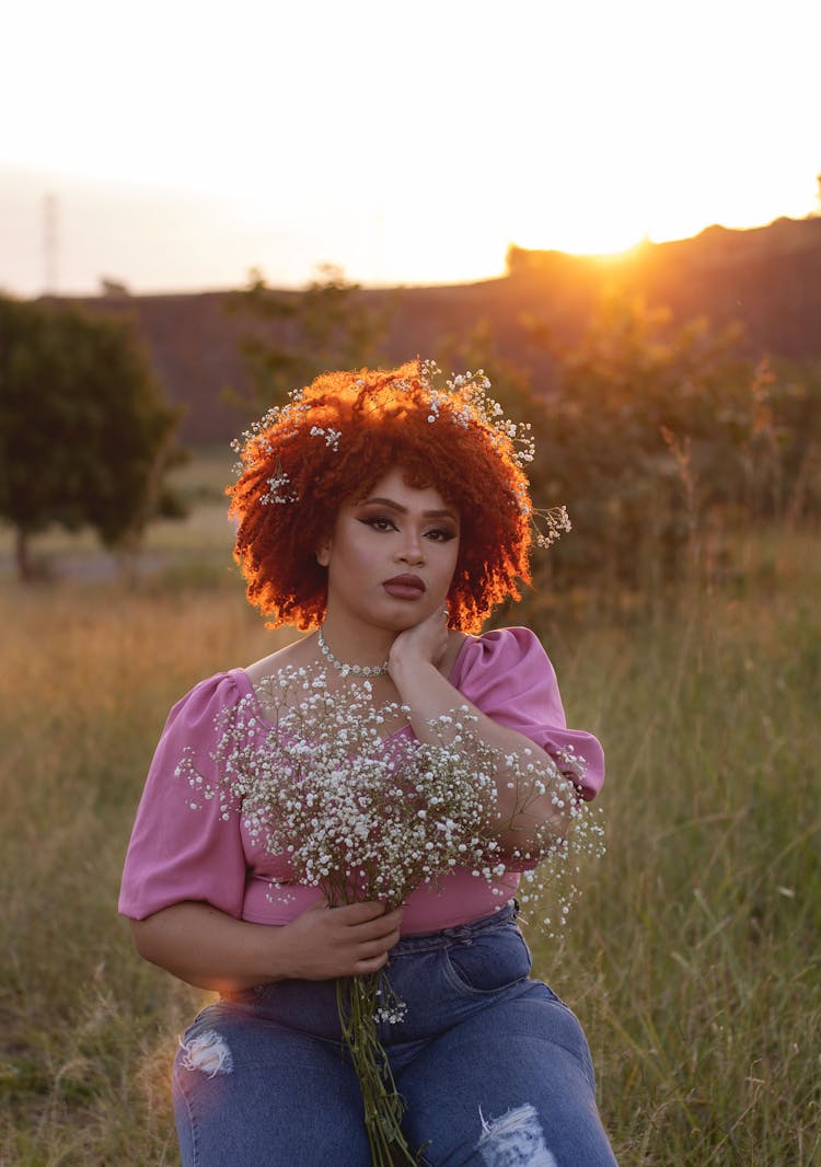 Woman In Red Afro Holding Bouquet Of White Flowers In Field