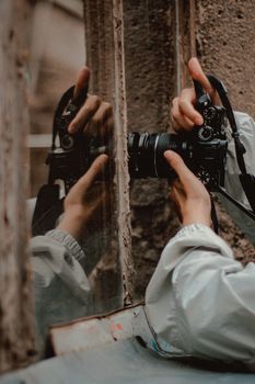 Close-up of a photographer taking a picture with reflection in window.