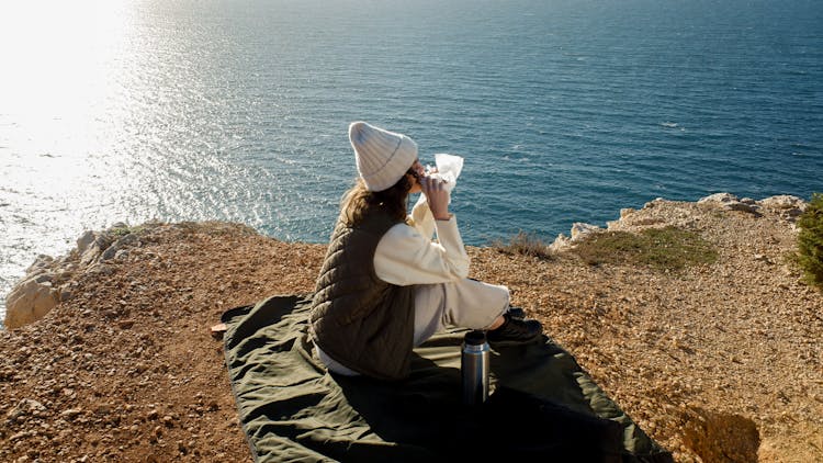 Woman Eating By The Cliff