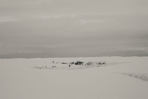 Free A serene snowy landscape featuring a remote encampment under cloudy skies. Stock Photo