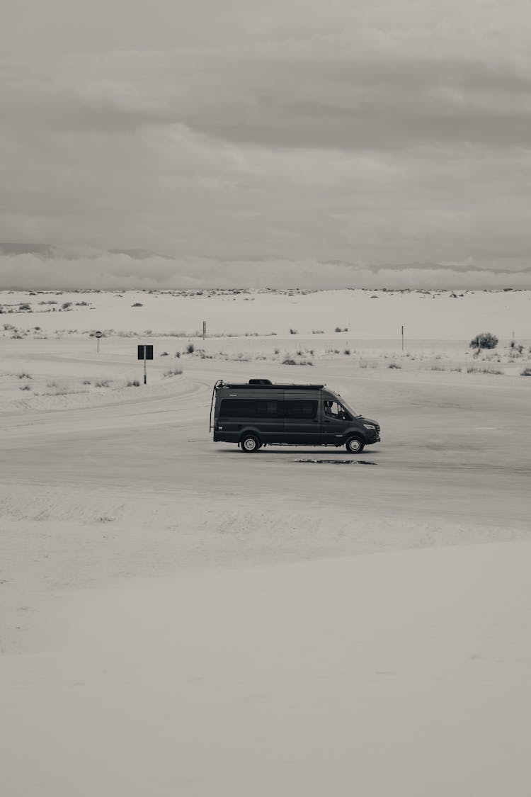 Black Van Travelling On A Snow Field