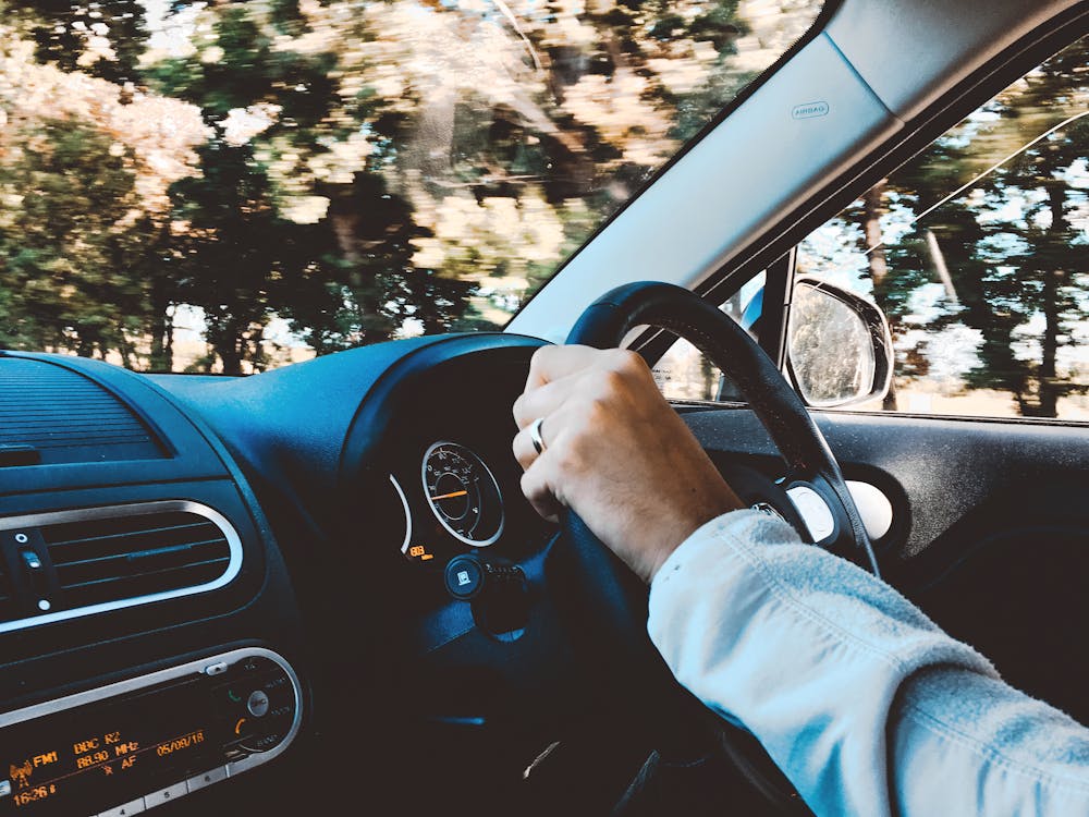 Free Person Holding Black Vehicle Steering Wheel Stock Photo