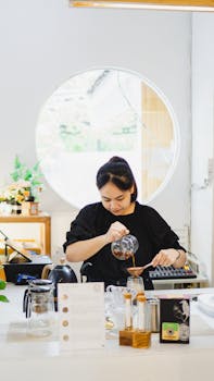 Asian woman brews coffee at a café in Madiun, Indonesia, showcasing barista skills.