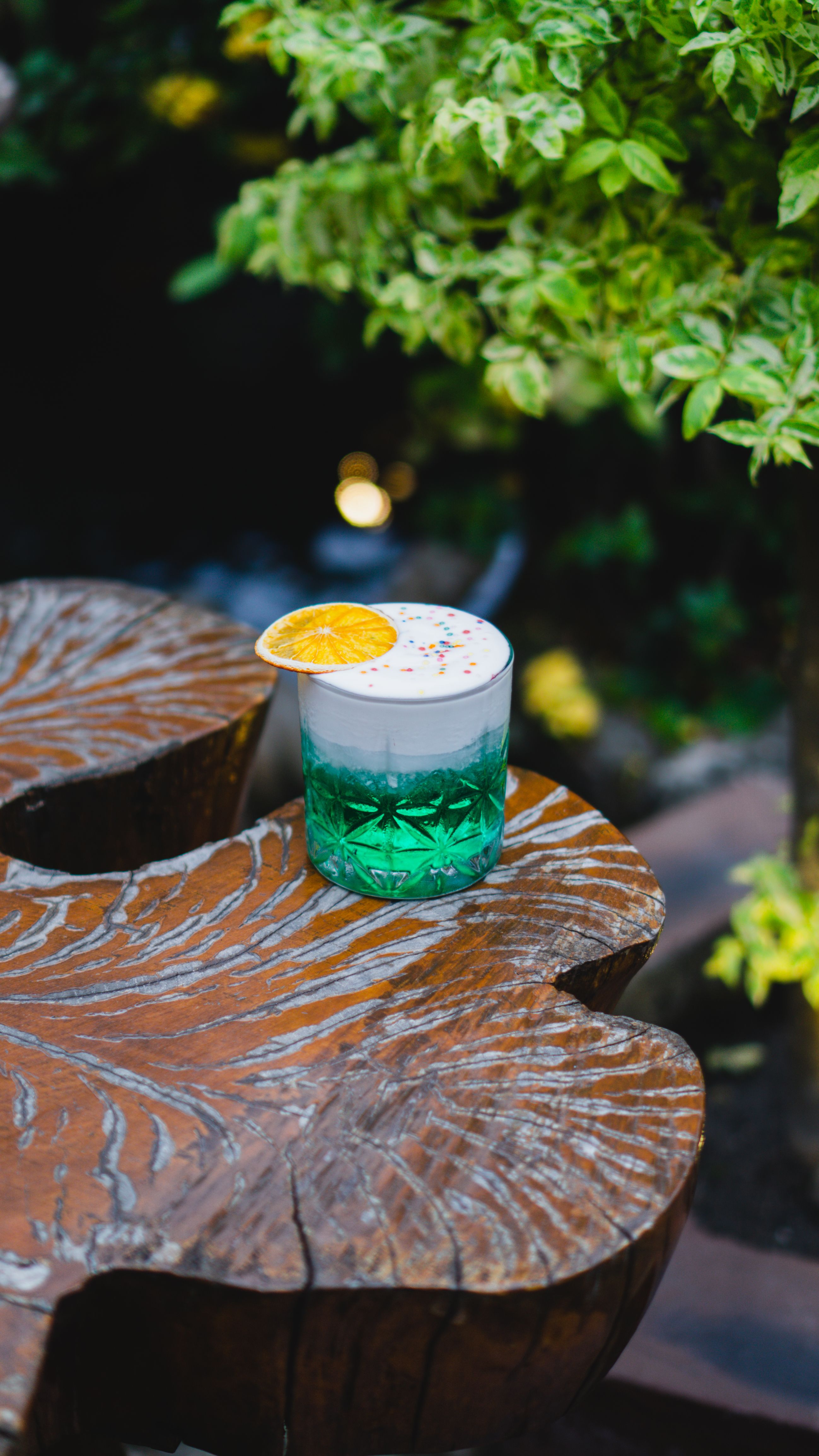 A vibrant tropical cocktail with orange garnish on a rustic wooden table, offering a refreshing summer vibe.