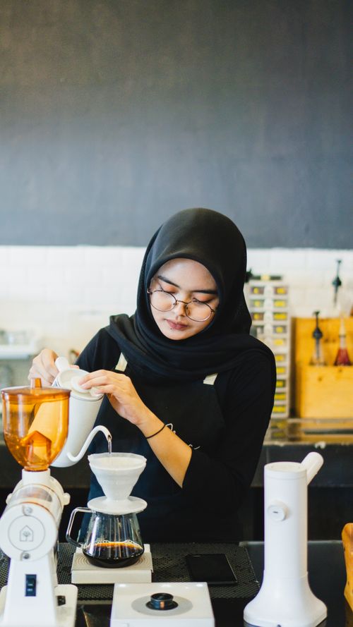Free Young barista crafting coffee in a stylish cafe in Madiun, Indonesia. Stock Photo
