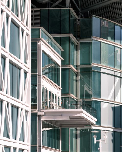 Free Detailed view of a modern building facade with glass walls reflecting light. Stock Photo