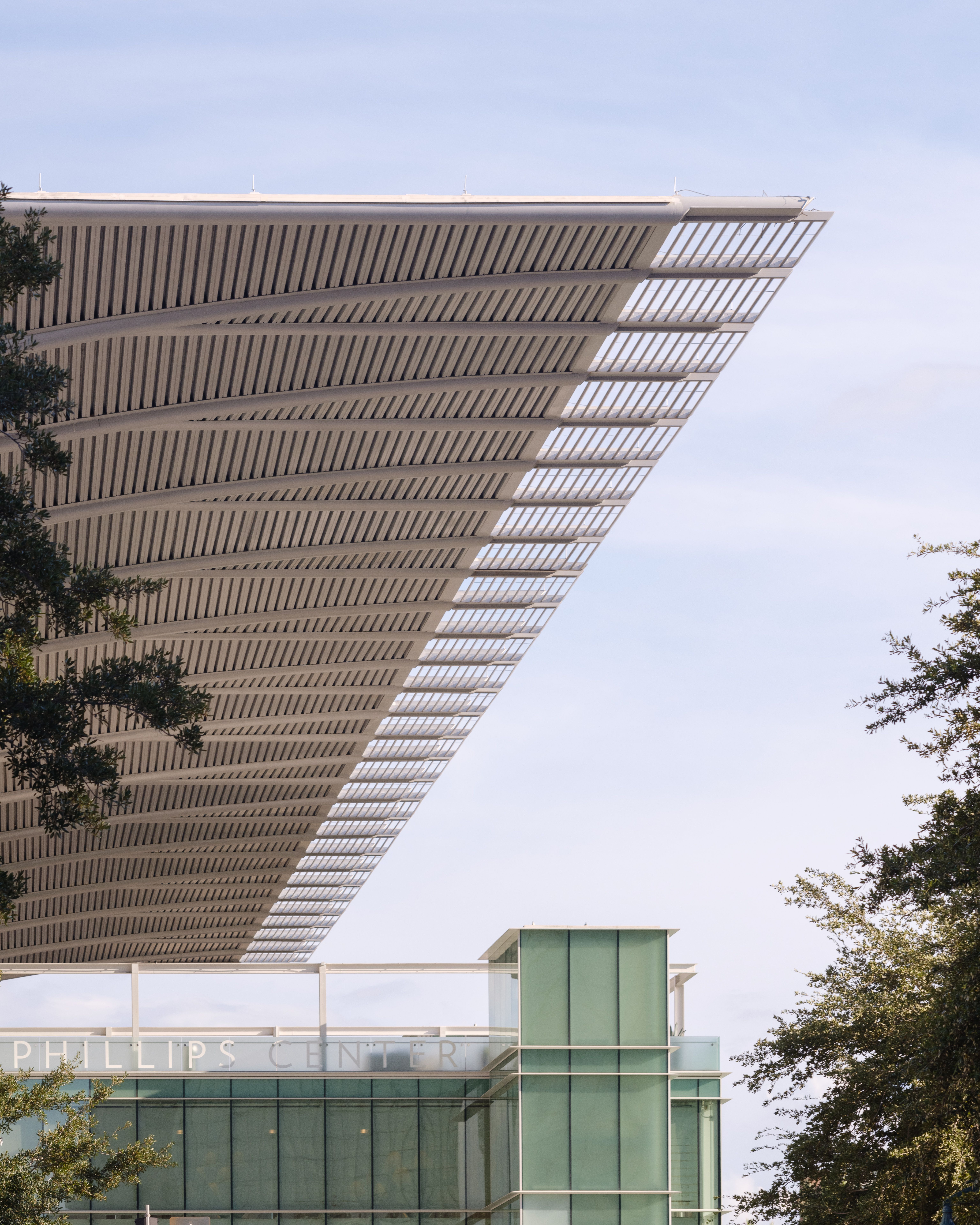 Futuristic building with sleek roof overhang against a blue sky. Ideal for modern architecture themes.