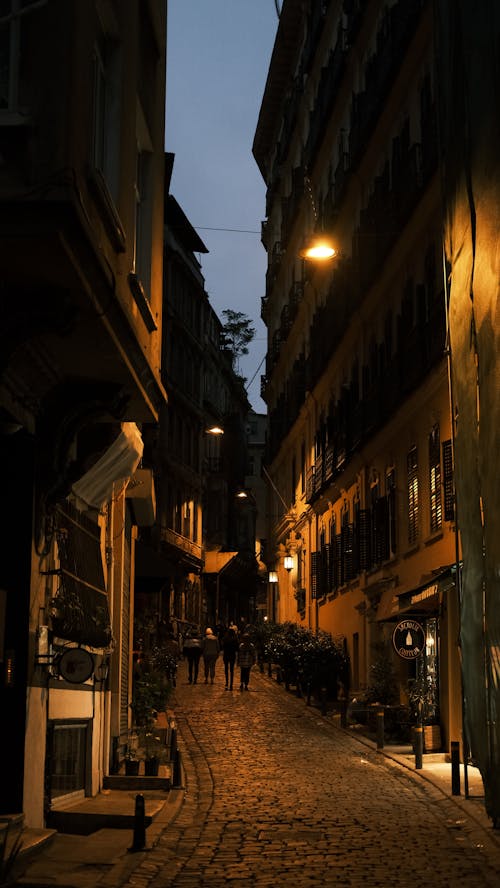 Foto profissional grátis de andando, edifícios de concreto, noite