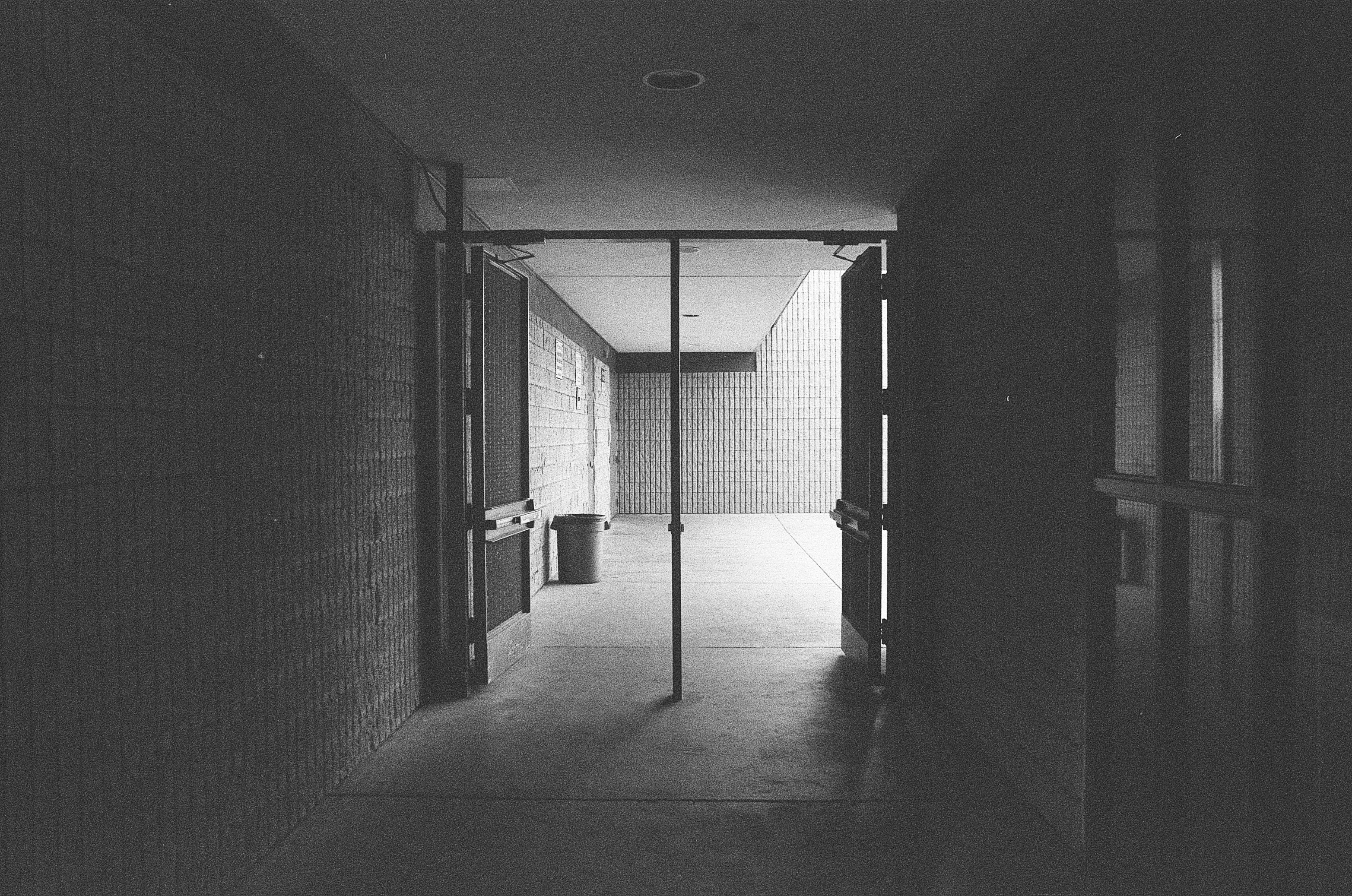 Pasillo escolar vacío bajo una luz tenue y sombría