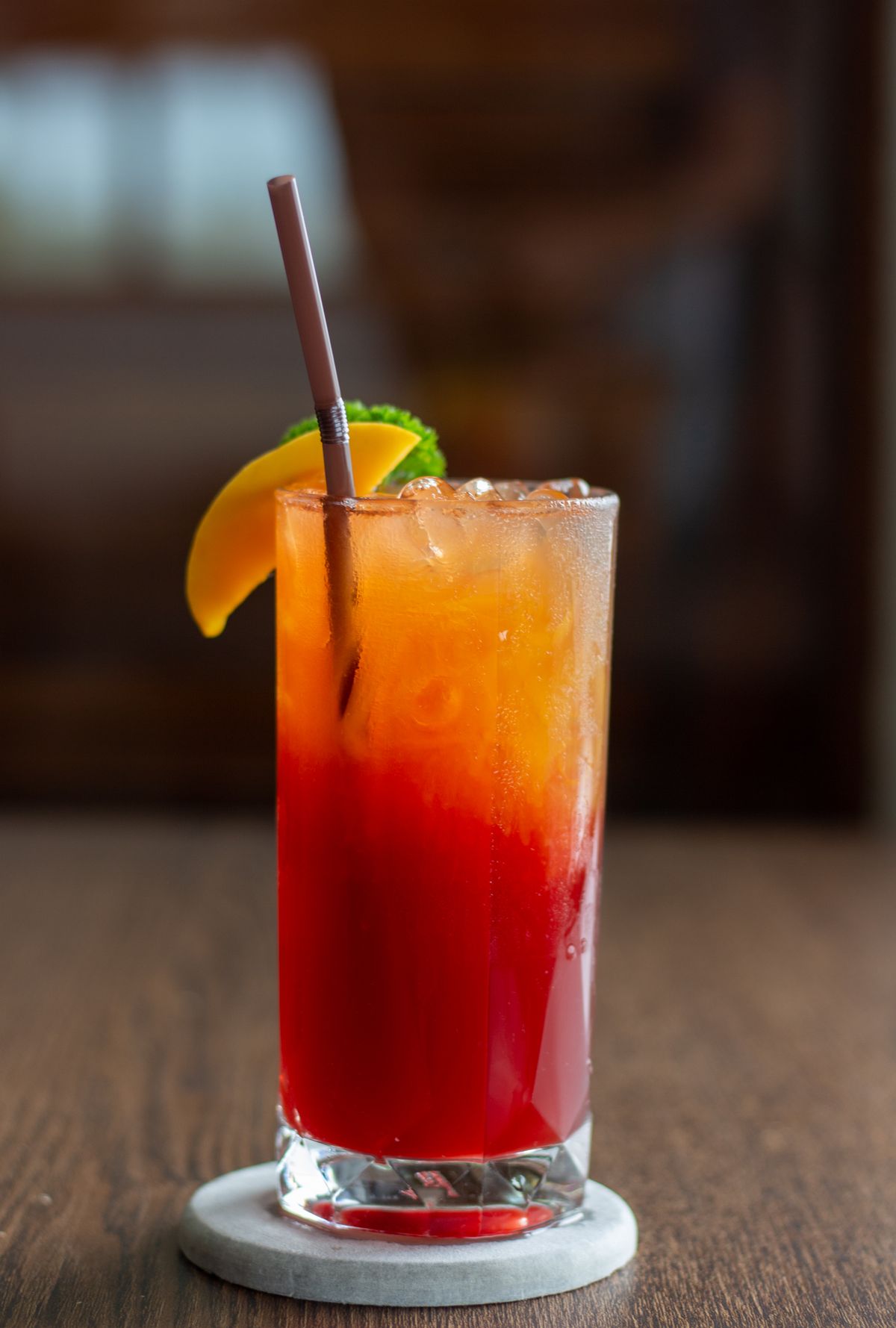 A refined non-alcoholic fruit drink served in a tall glass