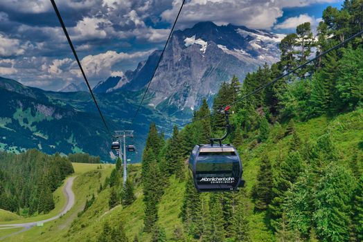 Scenic view of a cable car traversing the Swiss Alps in Grindelwald, perfect for travel enthusiasts.