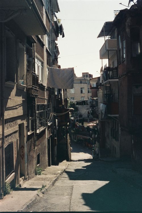 Free Narrow urban alley with clotheslines and hanging laundry between rustic buildings. Stock Photo