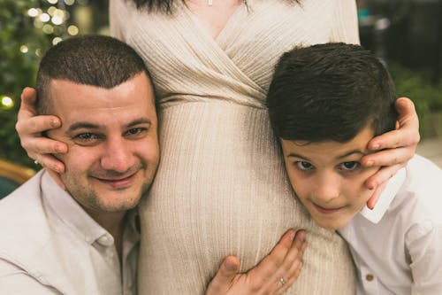 Woman Embracing Man and Child in White Shirts