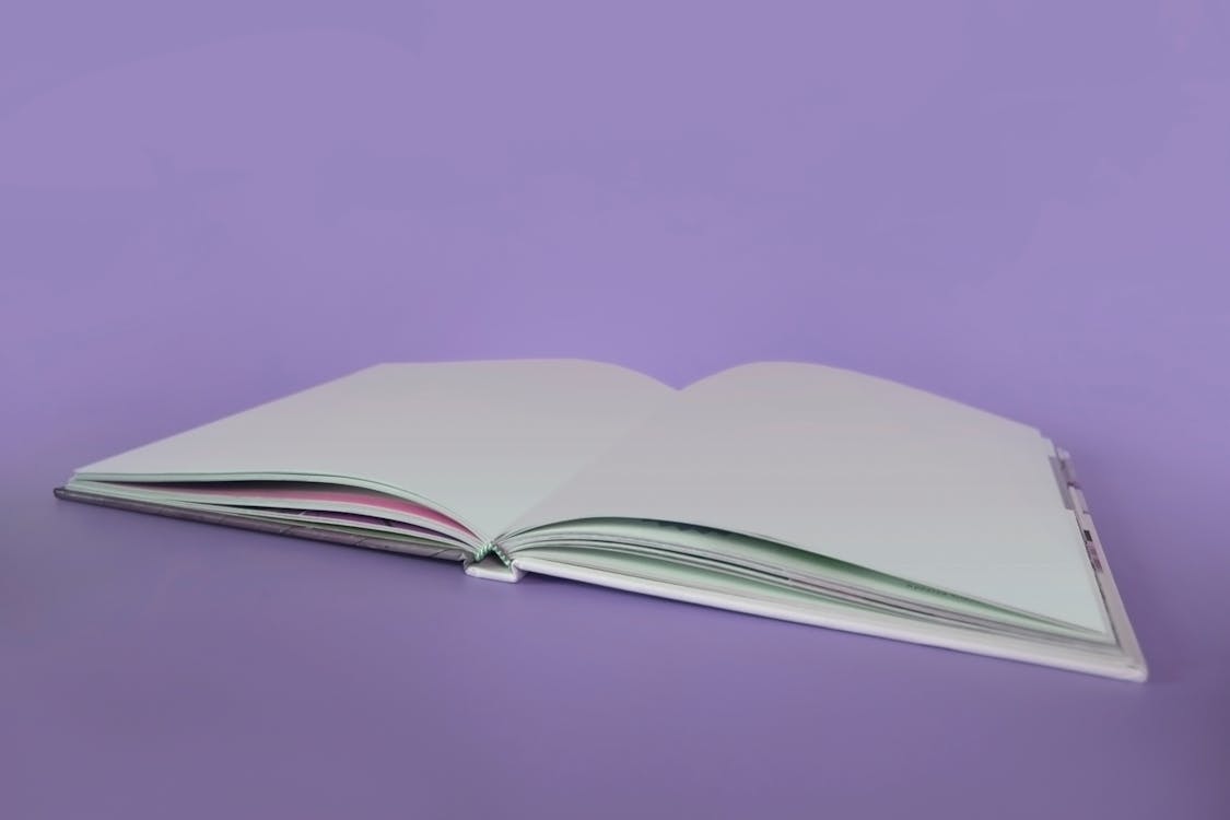 Opened Book on Purple Surface