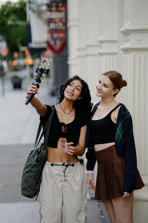 Free Two young women capture a selfie together on an urban street, showcasing friendship and modern lifestyle. Stock Photo