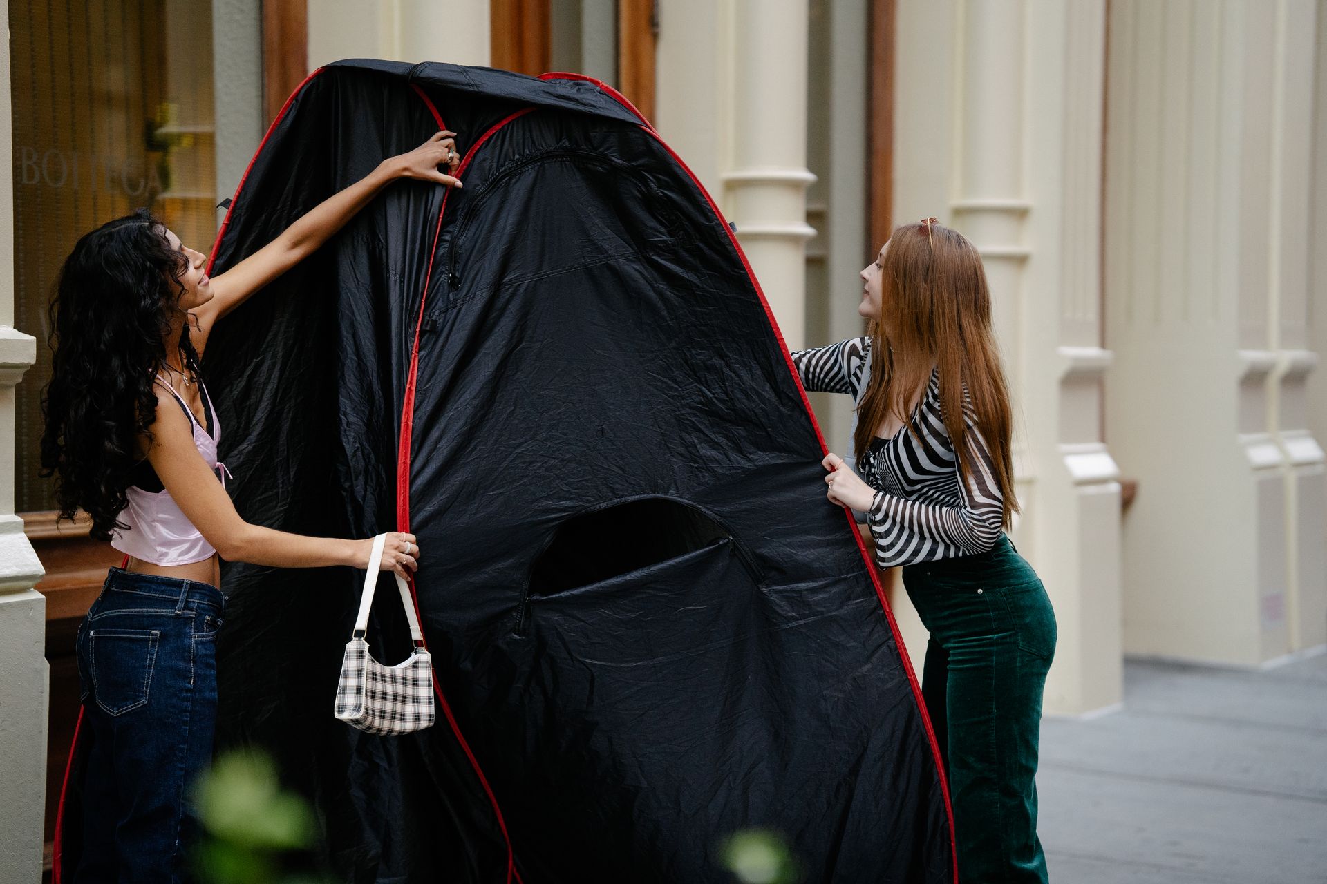 Young Girls Setting Up a Portable Changing Room in City