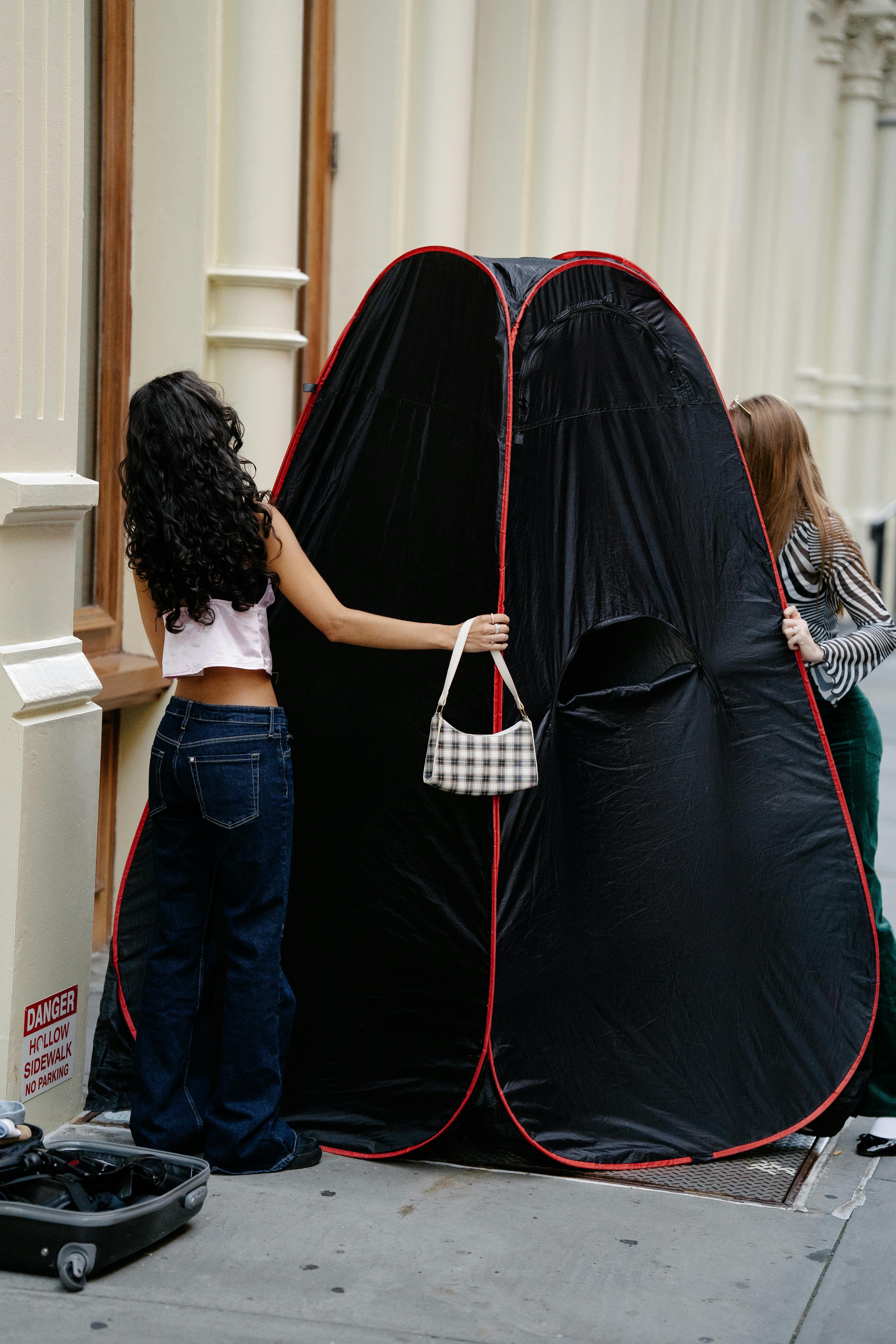 Young Girls Setting Up a Portable Changing Room in City · Free Stock Photo