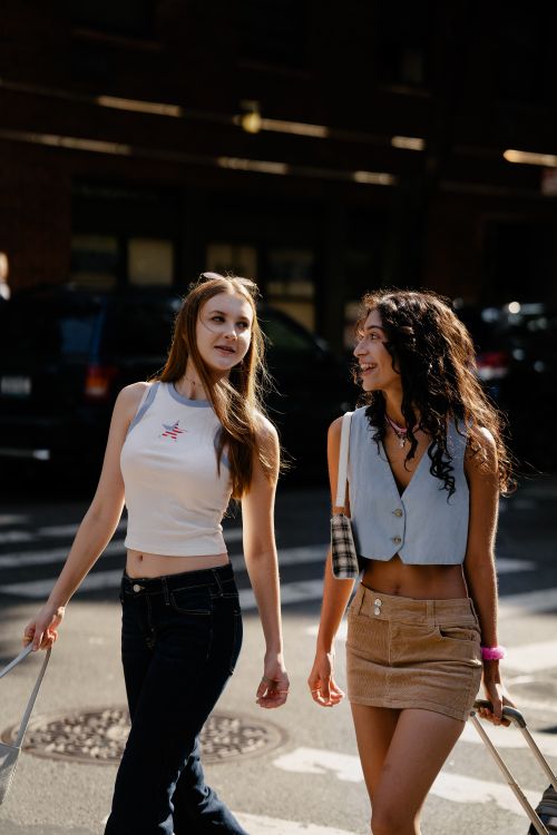 Free Two fashionable young women enjoying a walk on a sunny city street. Stock Photo