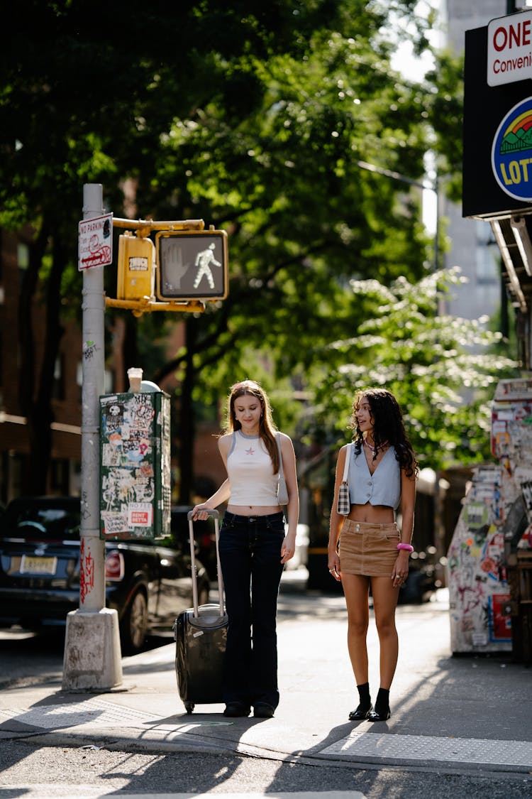 Young Girls Walking In City With A Suitcase 