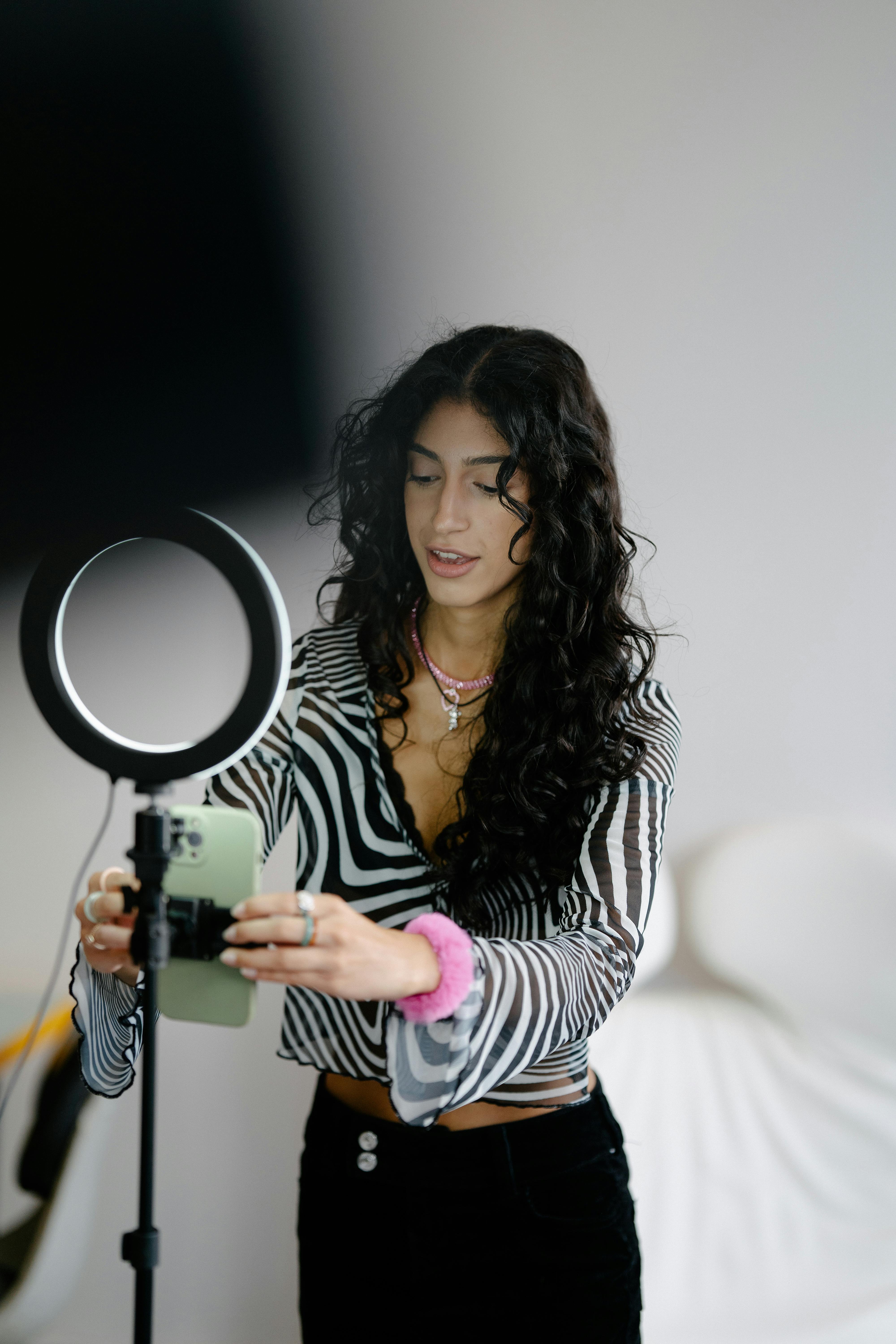 woman fixing a smart phone on a tripod in a studio