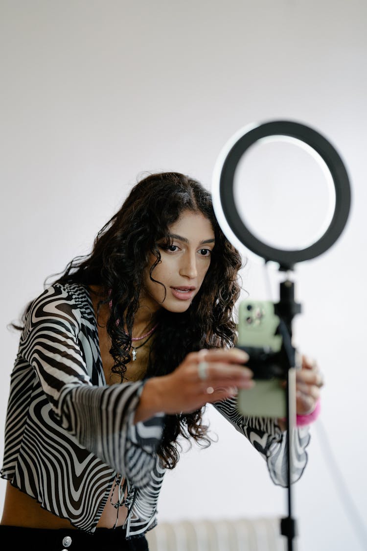 Woman Fixing A Smart Phone On A Tripod 