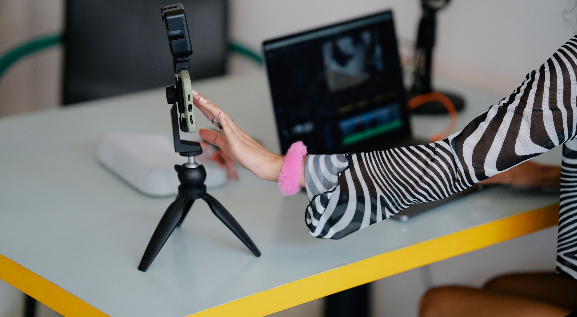 A videographer setting up a camera and laptop