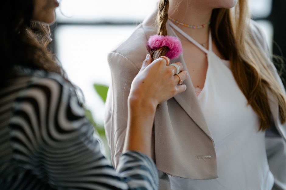 A close-up shot of a stylish braid being made with a pink hairband indoors, highlighting fashion and hair styling.