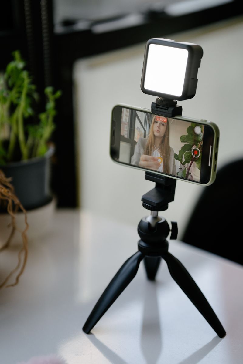 Creador grabando un video con teléfono, luces y equipo de audio