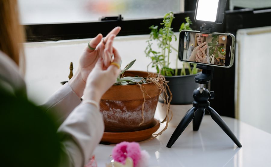 Content creator recording a video with a smartphone on a tripod