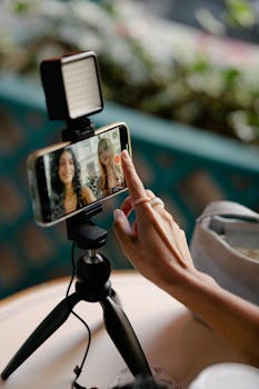 Two women engage in a video call using a smartphone mounted on a tripod, showcasing modern communication technology.