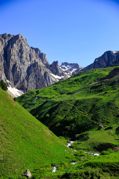 Free Breathtaking view of green valleys and rocky mountains in Tunceli, Turkey, under a blue sky. Stock Photo
