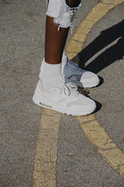 A Person Wearing White Sneakers 