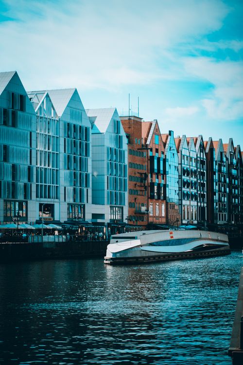 Free Scenic view of modern buildings and boat along the Gdańsk canal, Poland Stock Photo