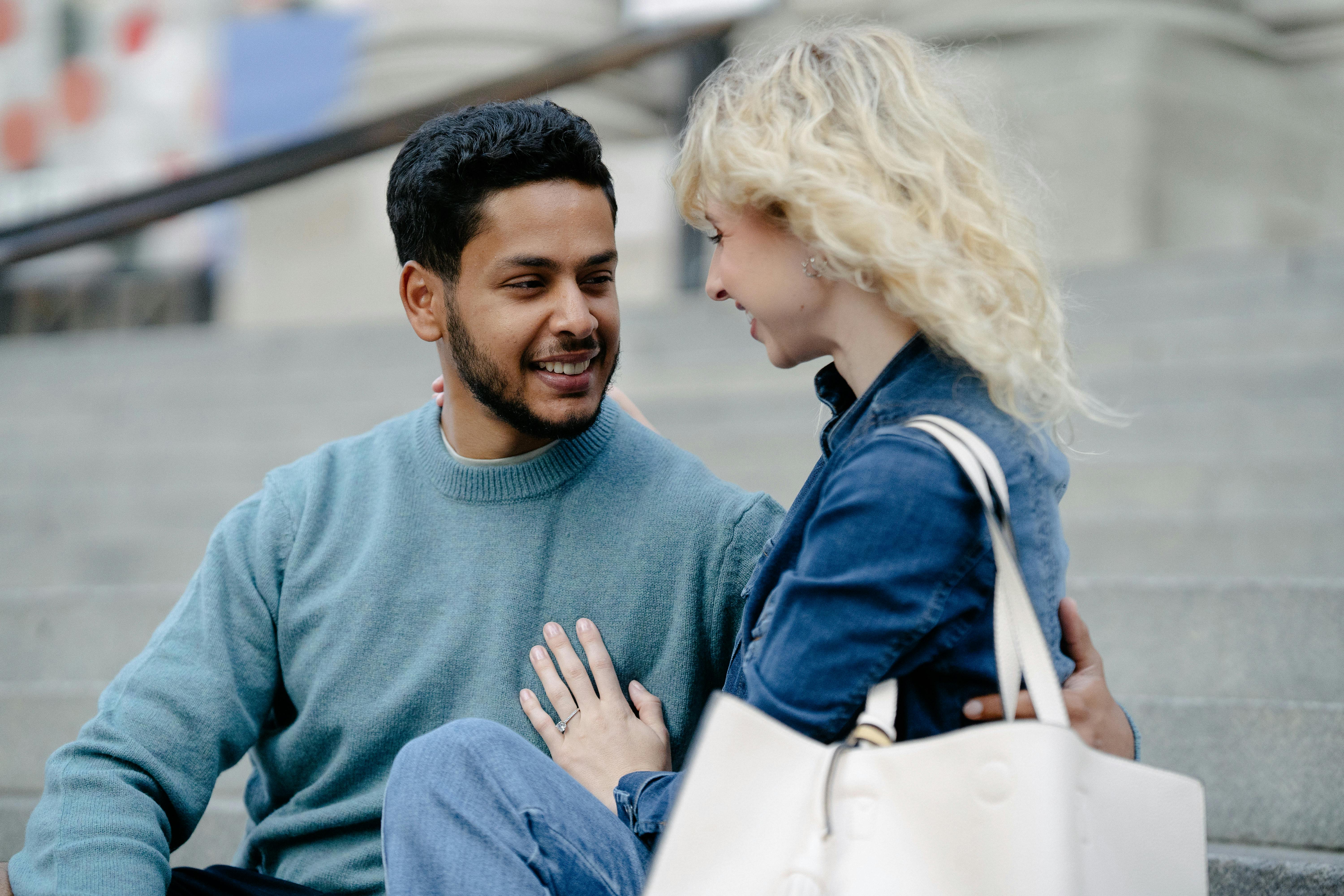 Cheerful couple enjoying a moment together on steps, radiating happiness.