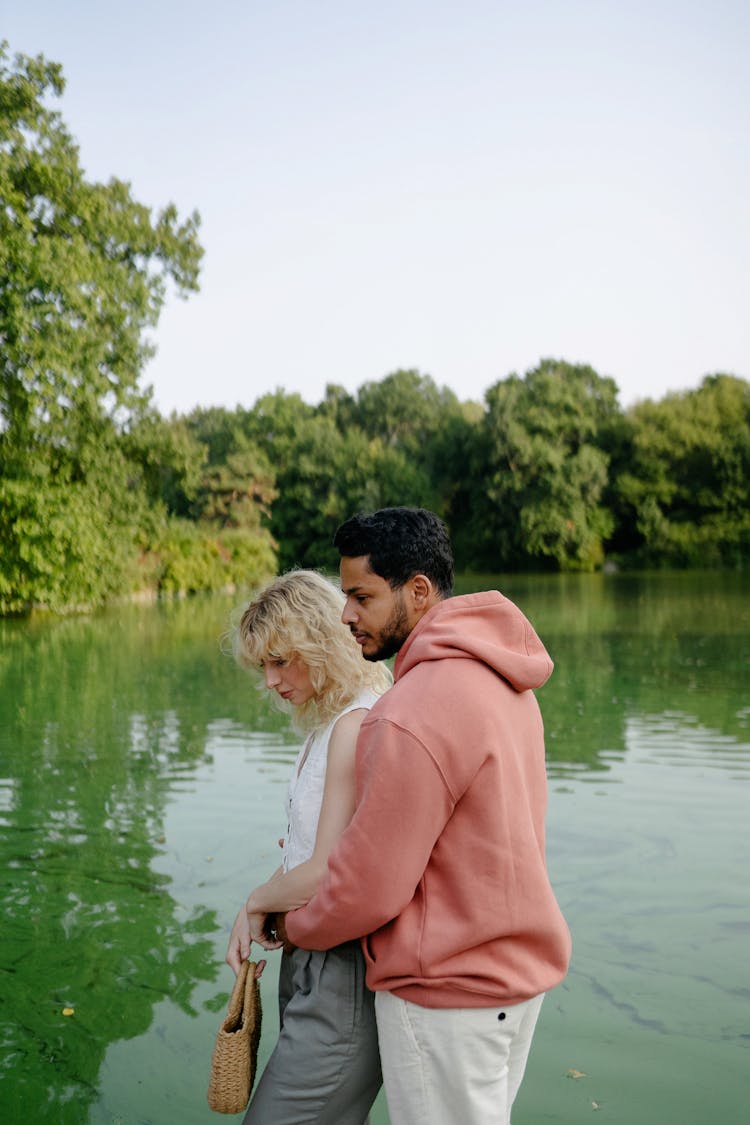 Man Hugging Woman On Lakeshore