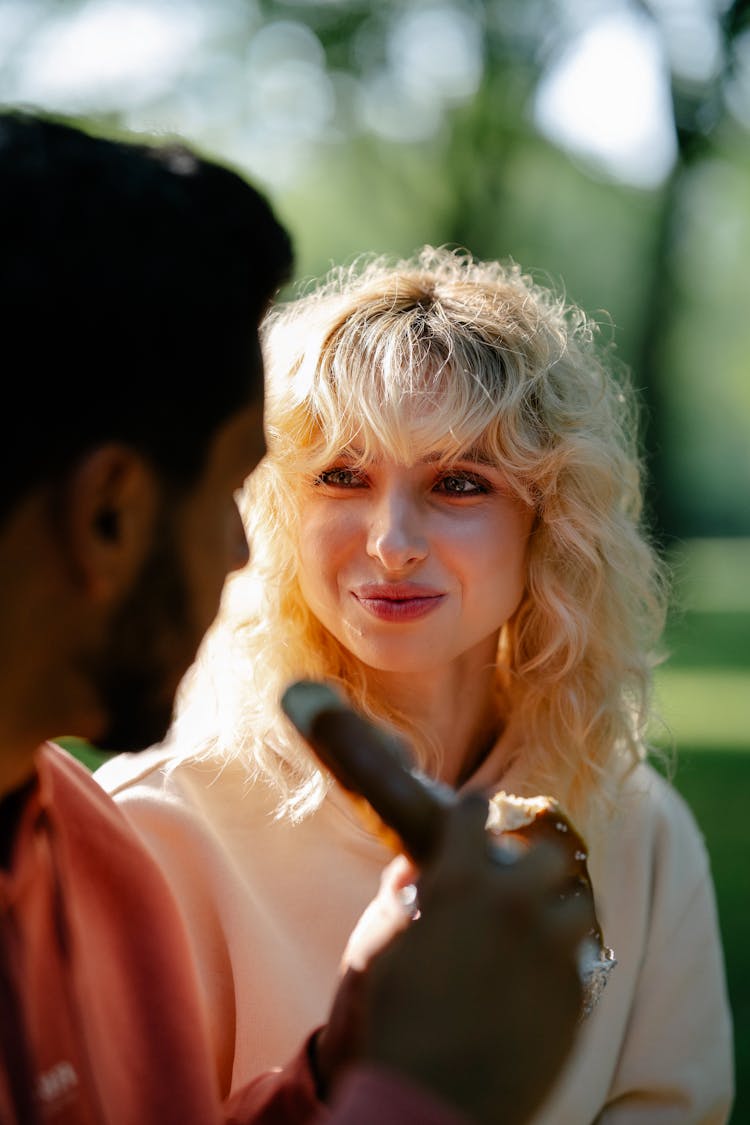 Woman Looking At Man Eating Pretzel