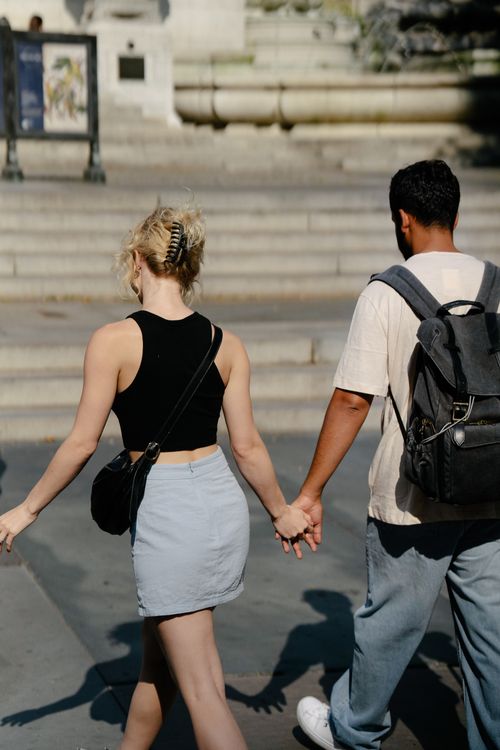 Free A couple walking hand in hand on city steps, showcasing urban lifestyle and connection. Stock Photo