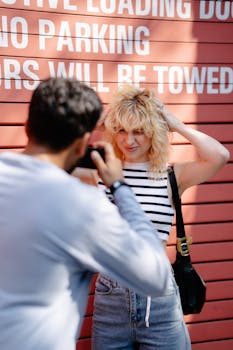 Casual street photo of models posing against a red garage door with bold text.