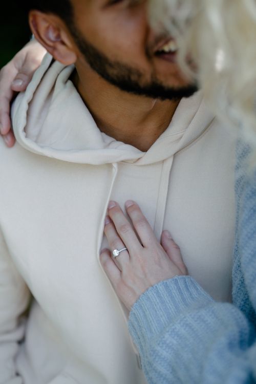 Free Close-up of a couple's romantic embrace highlighting an engagement ring. Stock Photo