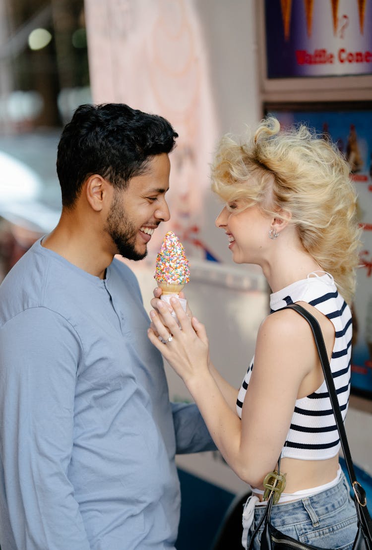 Woman With Tousled Hair Offering An Ice Cream To A Man