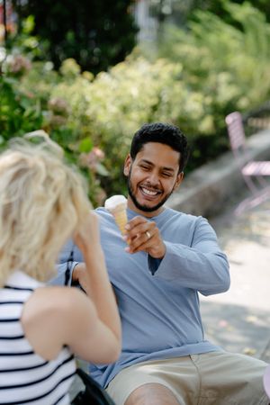 Couple sharing ice cream in a sunny park, photo by Mizuno K on Pexels
