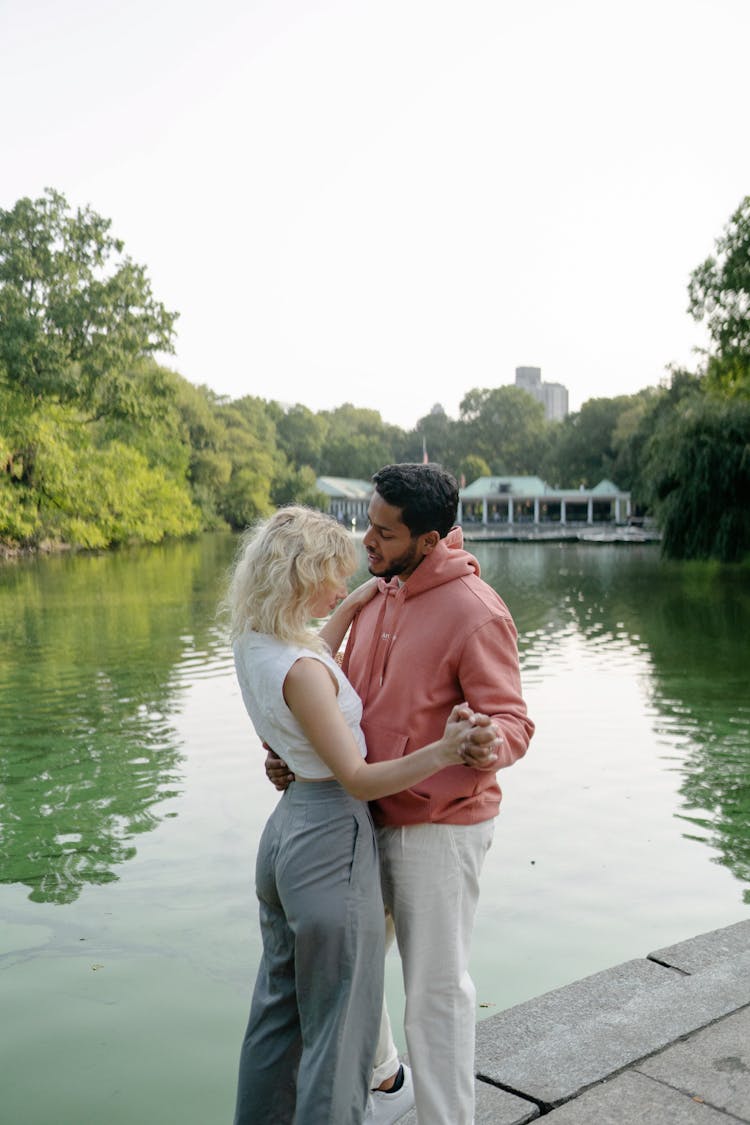 A Couple Standing By A Lake