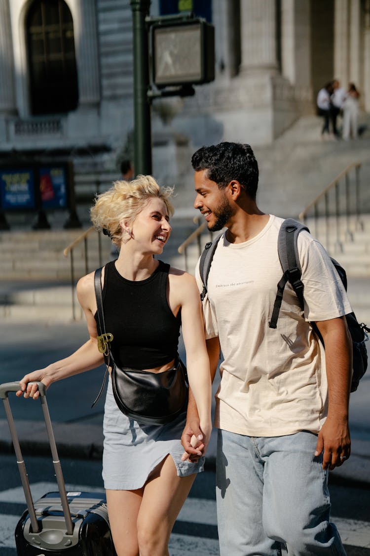 Smiling Couple Walking With Suitcase In City