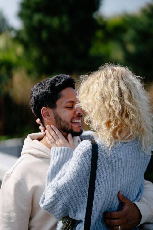 Free Happy couple embracing outdoors in a sunlit park, exuding warmth and joy. Stock Photo