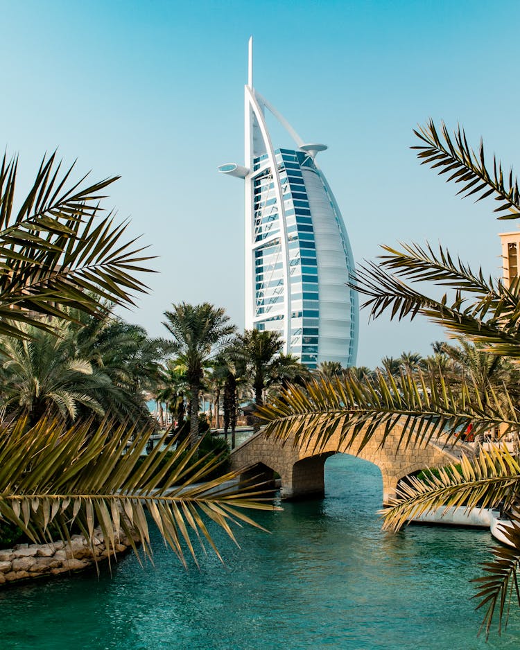 Building Of The The Burj Al Arab Hotel Behind Palm Trees And A Bridge, Dubai, United Arab Emirates