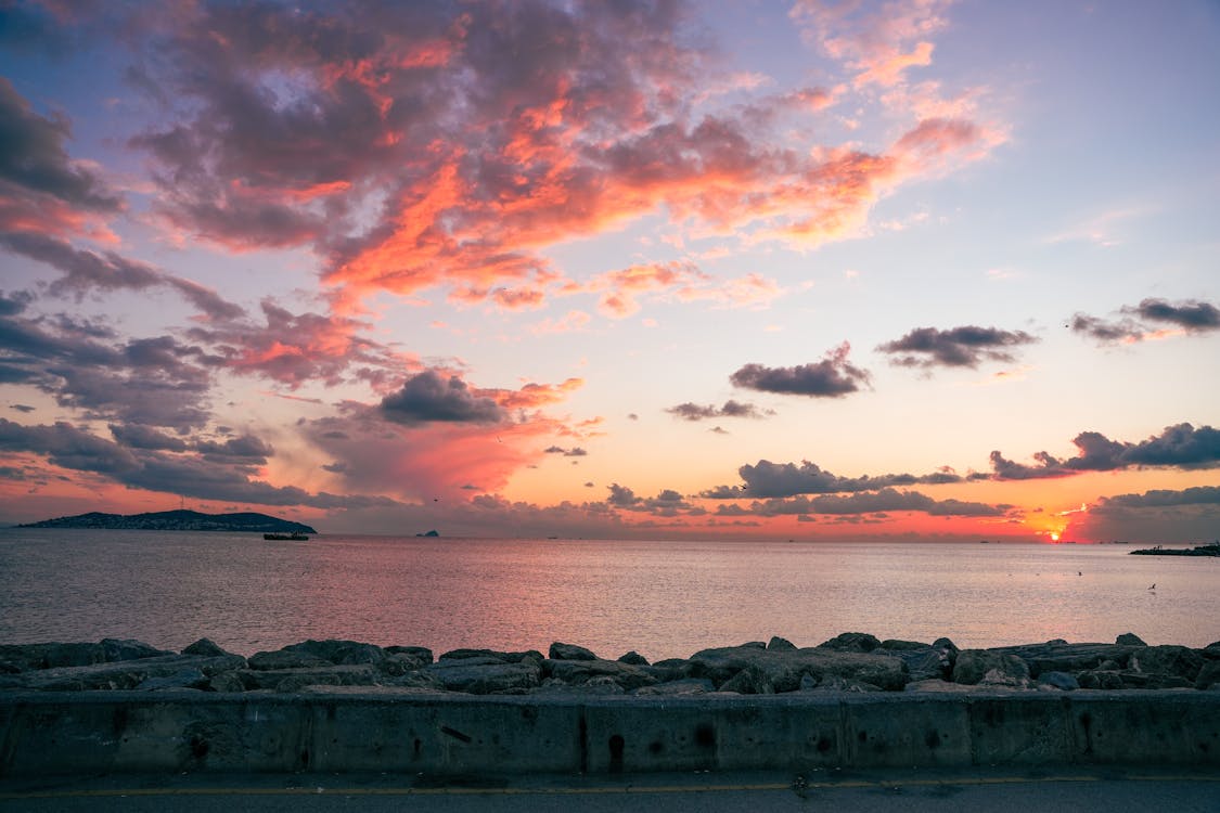 Body of Water Under Cloudy Sky during Sunset