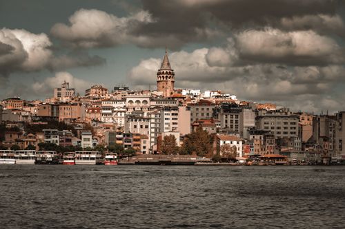 Free A captivating view of Galata Tower overlooking the bustling skyline of Istanbul by the water. Stock Photo