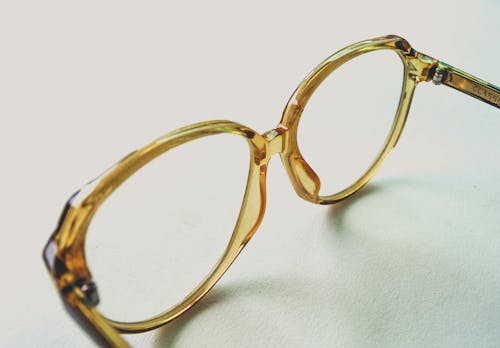 Yellow Frame Eyeglasses on White Surface